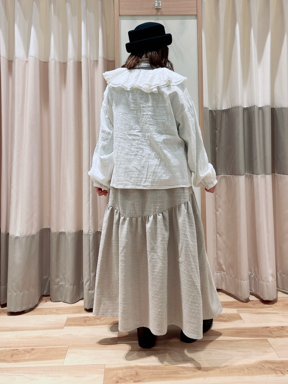 ホワイト系のニット/セーター、ホワイト系のシャツ/ブラウス、ホワイト系のスカートを着用したレディースの冬コーディネートの2枚目の写真