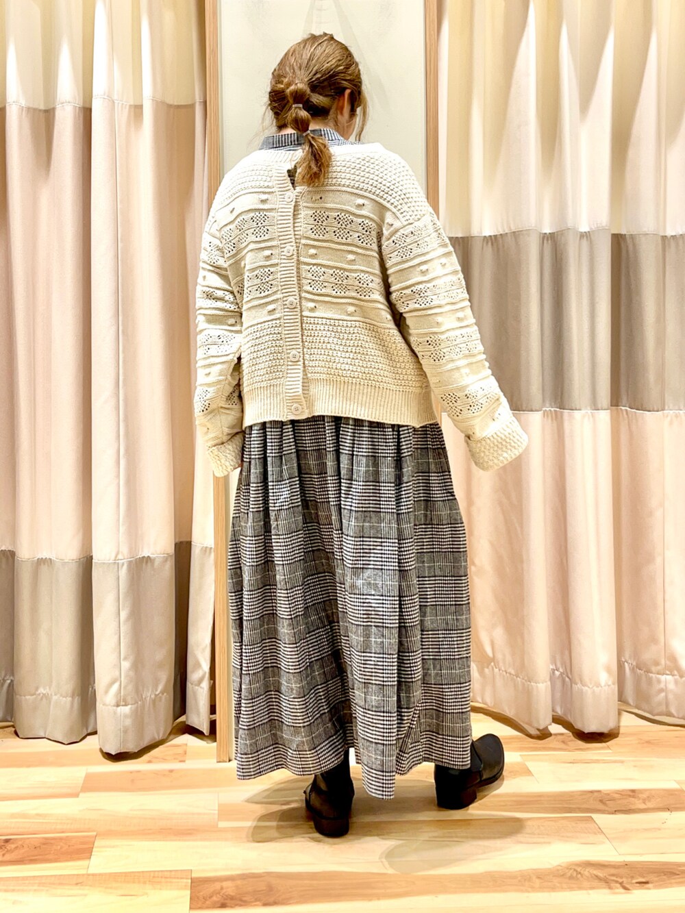 ホワイト系のニット/セーター、グレー系のワンピース、ブラック系のシューズを着用したレディースの冬コーディネートの2枚目の写真