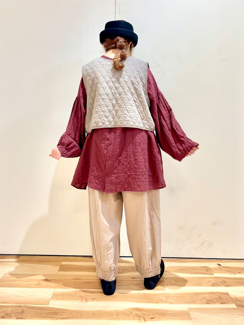 ベージュ系のベスト、レッド系のシャツ/ブラウス、ベージュ系のその他パンツを着用したレディースの秋コーディネートの2枚目の写真