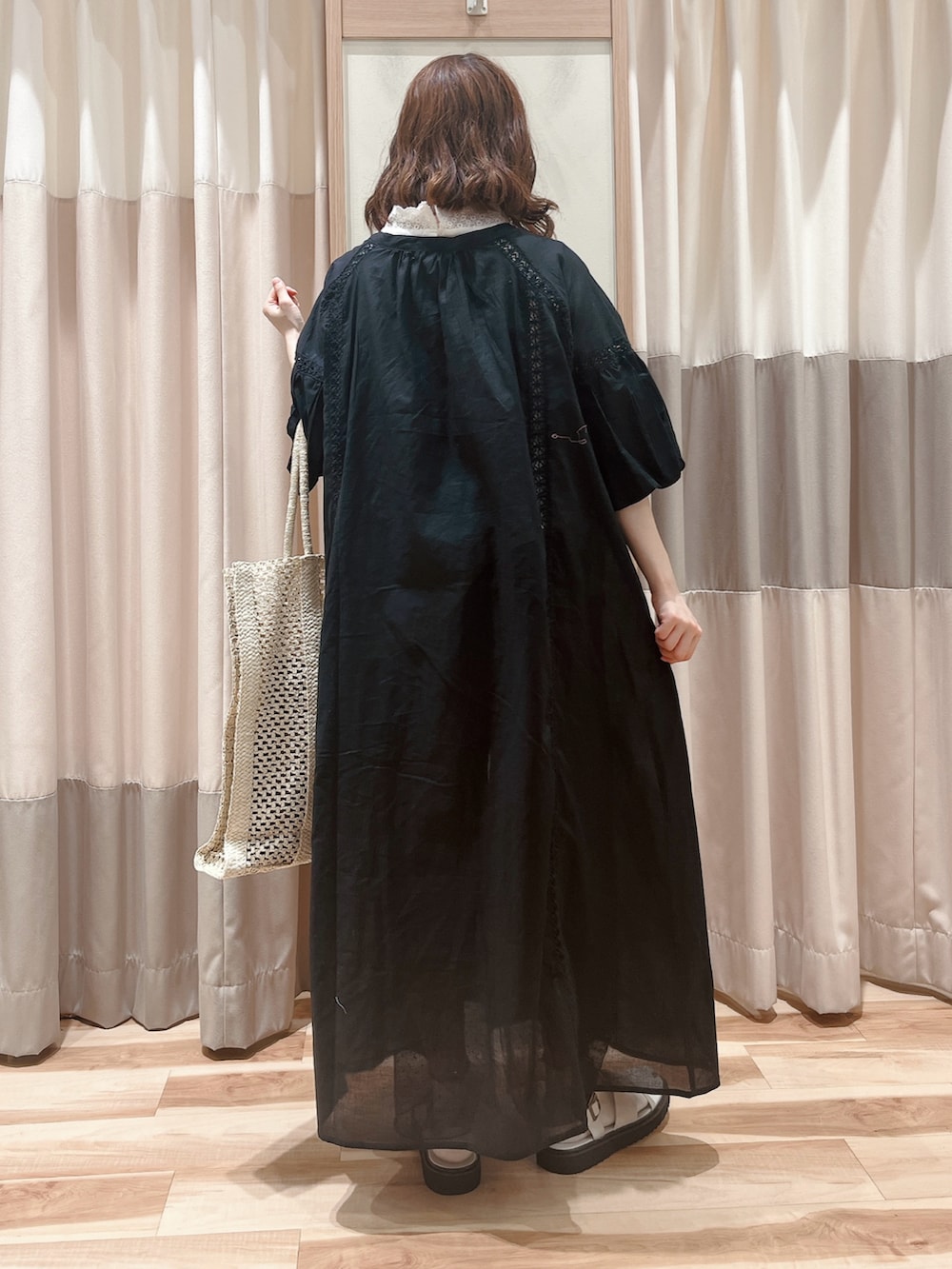 ブラック系のワンピース、ホワイト系のTシャツ/カットソー、ホワイト系のハンドバッグを着用したレディースの夏コーディネートの2枚目の写真