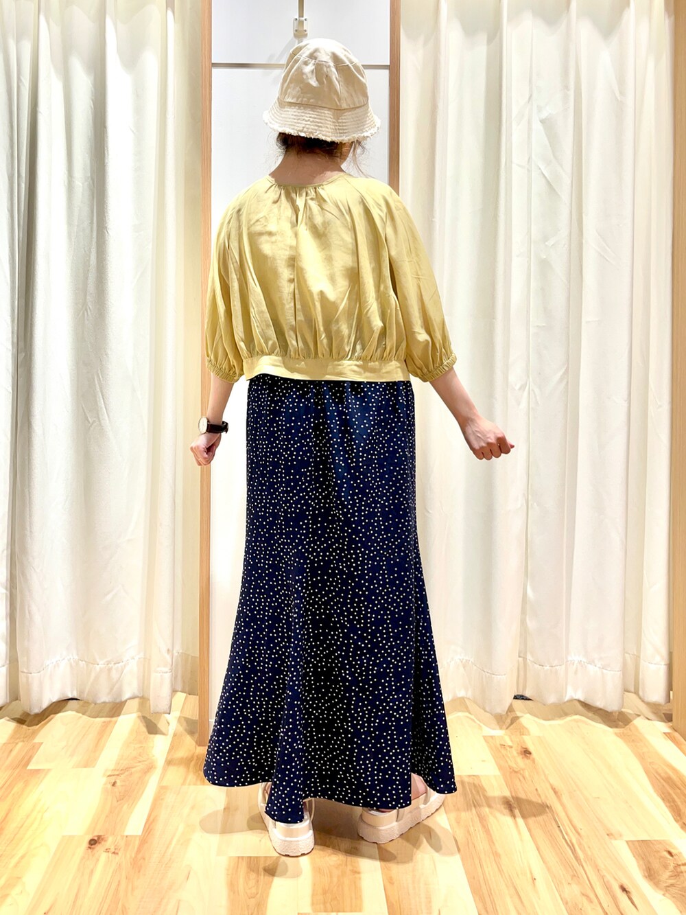 イエロー系のシャツ/ブラウス、ブルー系のスカート、ホワイト系のサンダルを着用したレディースの夏コーディネートの2枚目の写真