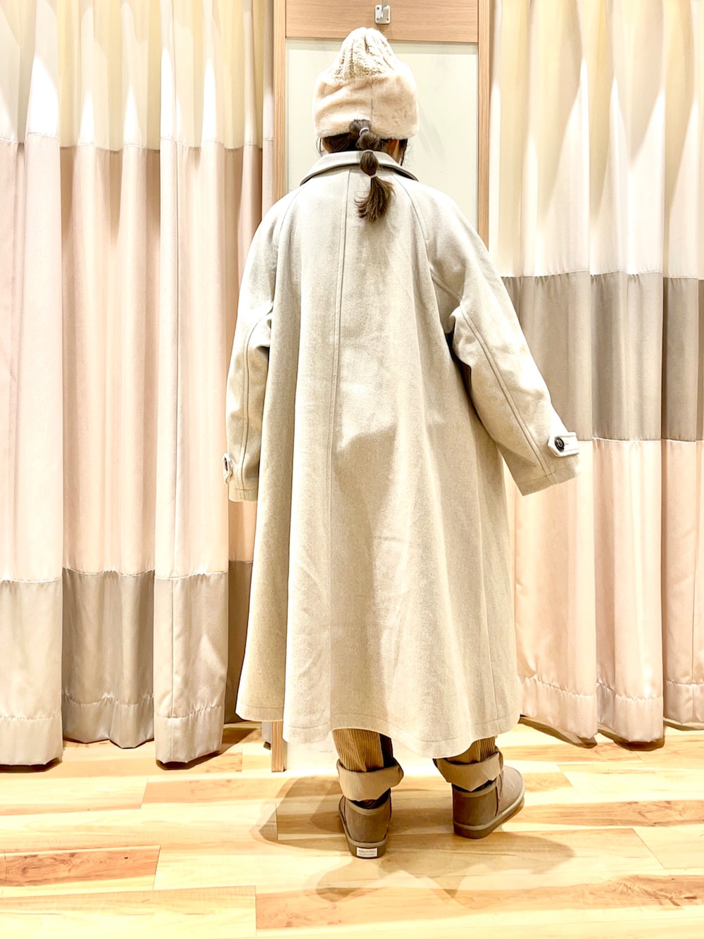 グリーン系のニット/セーター、ベージュ系のその他パンツ、ベージュ系のステンカラーコートを着用したレディースの冬コーディネートの2枚目の写真