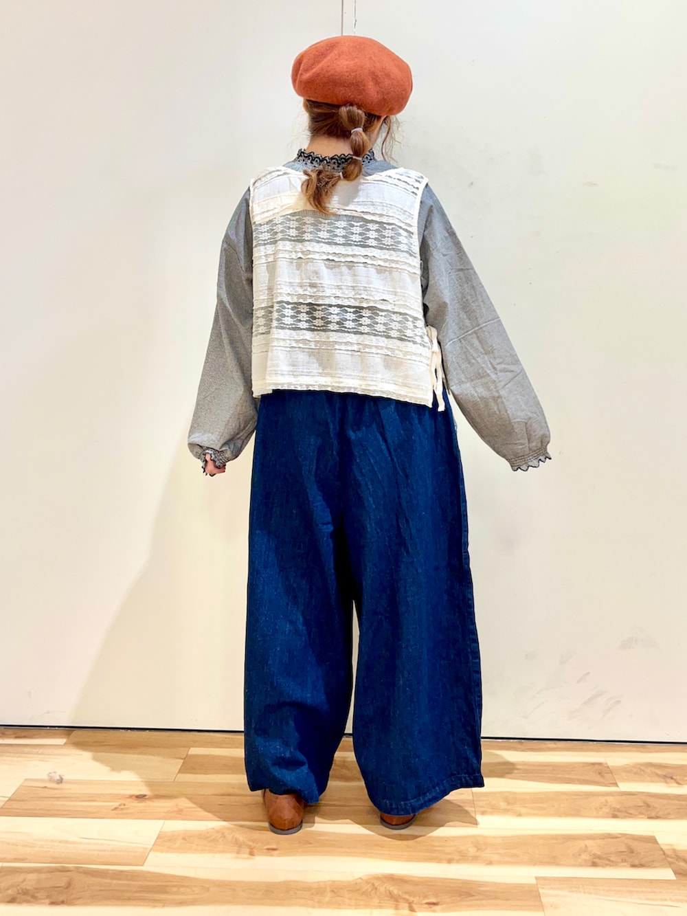 ホワイト系のベスト、ブラック系のシャツ/ブラウス、ブルー系のデニムパンツを着用したレディースの秋コーディネートの2枚目の写真