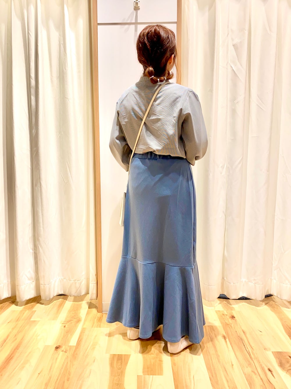 ブラック系のシャツ/ブラウス、ブルー系のスカート、ホワイト系のショルダーバッグを着用したレディースの春コーディネートの2枚目の写真