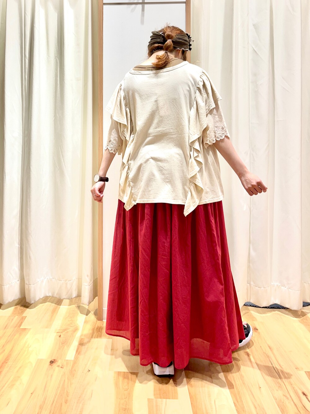 レッド系のスカート、ブラック系のサンダル、ホワイト系のTシャツ/カットソーを着用したレディースの夏コーディネートの2枚目の写真