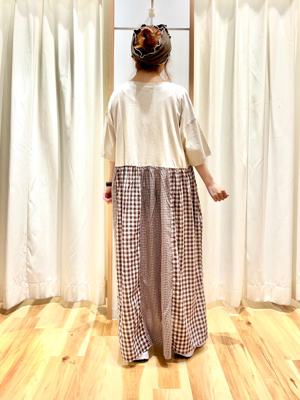 ベージュ系のワンピース、ブラック系のサンダル、ブラウン系のヘアバンドを着用したレディースの夏コーディネートの2枚目の写真