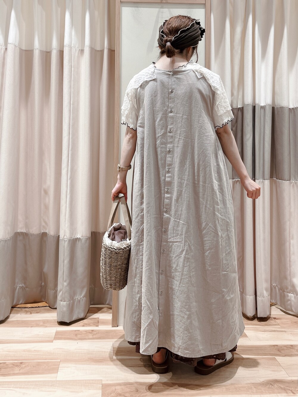 ベージュ系のワンピース、ホワイト系のTシャツ/カットソー、ブラウン系のスカートを着用したレディースの夏コーディネートの2枚目の写真