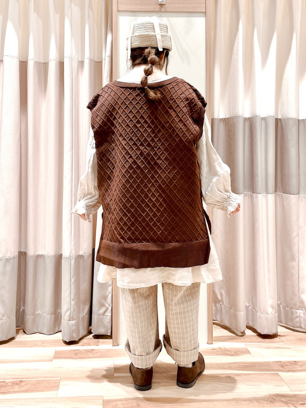 ブラウン系のベスト、ホワイト系のチュニック、ベージュ系のその他パンツを着用したレディースの春コーディネートの2枚目の写真