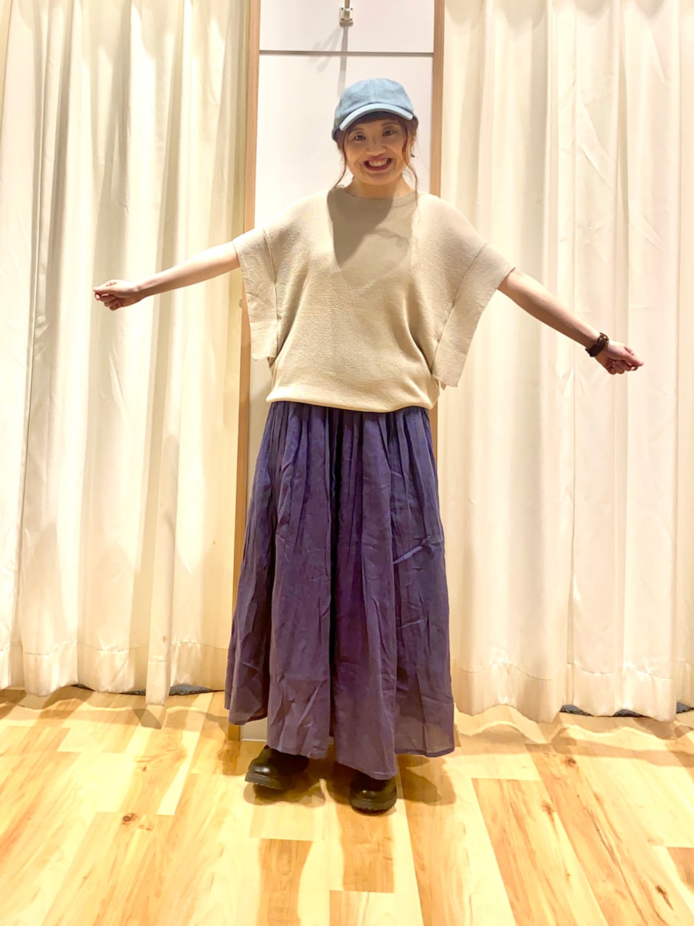 ベージュ系のニット/セーター、ブルー系のスカート、ブラック系のその他シューズを着用したレディースの春コーディネートの3枚目の写真