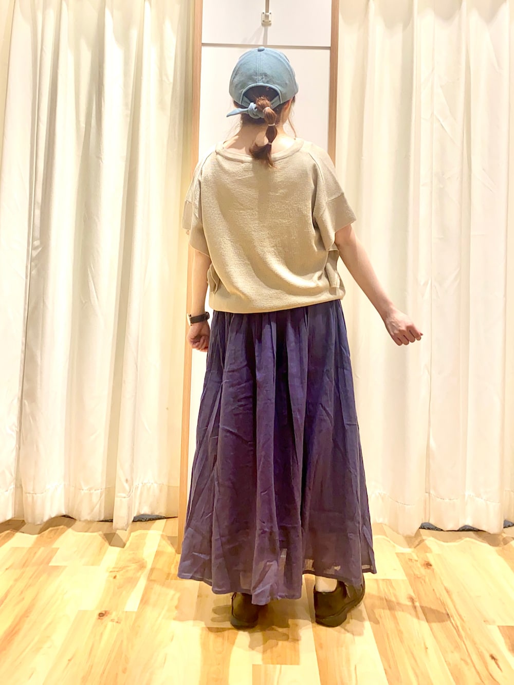 ベージュ系のニット/セーター、ブルー系のスカート、ブラック系のその他シューズを着用したレディースの春コーディネートの2枚目の写真