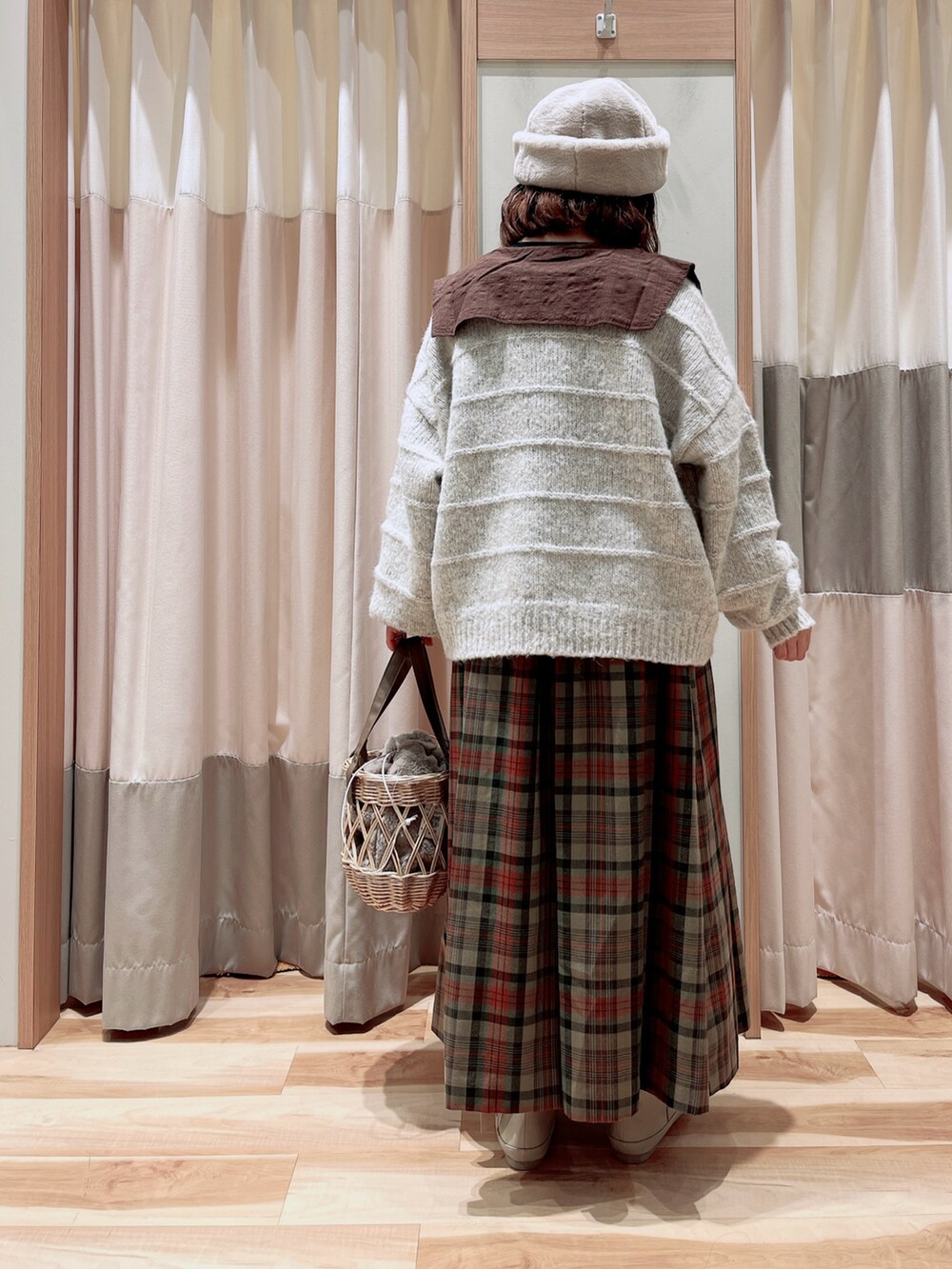 ホワイト系のカーディガン/ボレロ、ブラウン系のシャツ/ブラウス、レッド系のスカートを着用したレディースの冬コーディネートの2枚目の写真