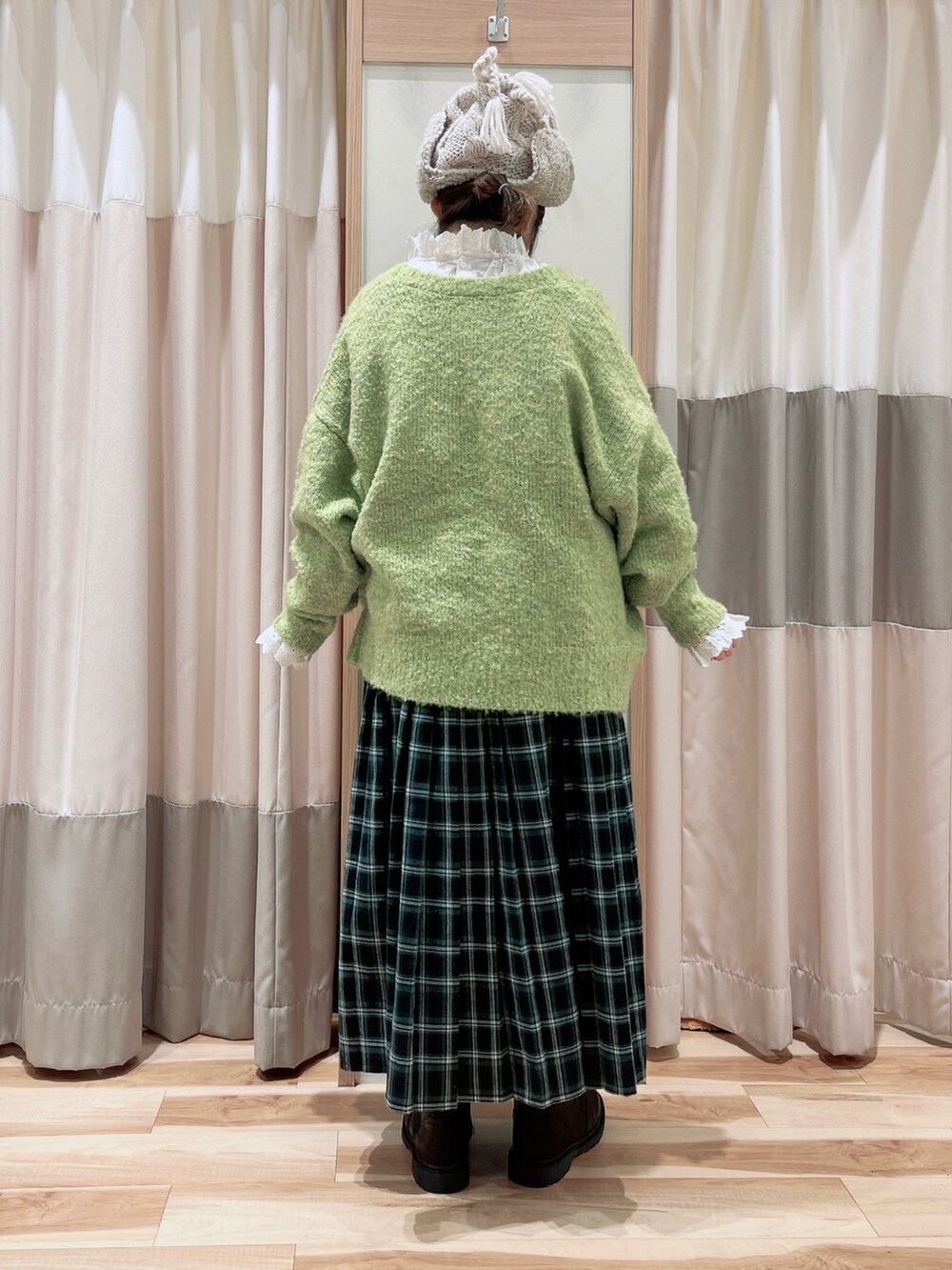 グリーン系のカーディガン/ボレロ、ホワイト系のシャツ/ブラウス、グリーン系のスカートを着用したレディースの冬コーディネートの2枚目の写真