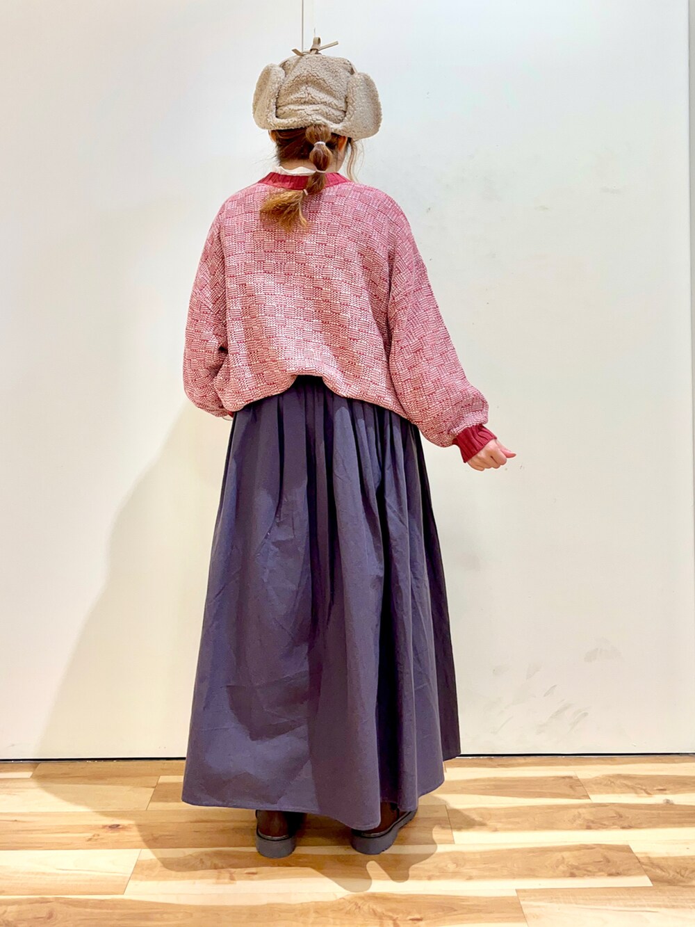 ピンク系のニット/セーター、ホワイト系のシャツ/ブラウス、グレー系のスカートを着用したレディースの秋コーディネートの2枚目の写真