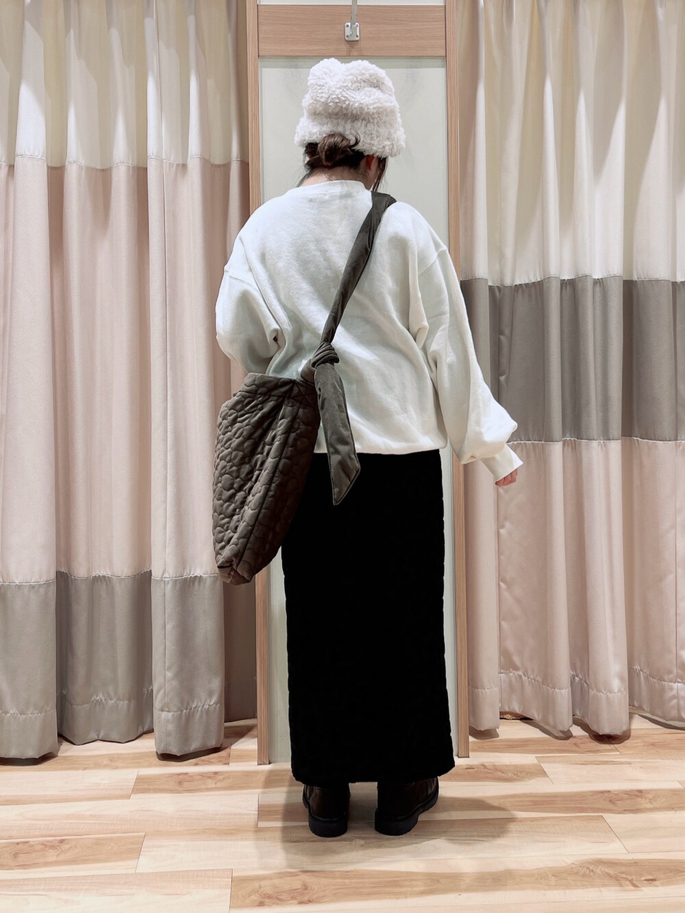 ホワイト系のTシャツ/カットソー、ブラック系のスカート、ブラウン系のハンドバッグを着用したレディースの冬コーディネートの2枚目の写真