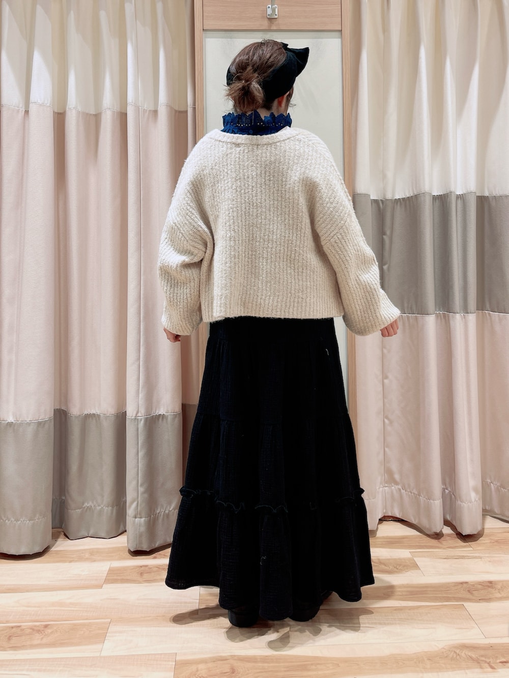 ホワイト系のカーディガン/ボレロ、ブルー系のシャツ/ブラウス、ブラック系のスカートを着用したレディースの冬コーディネートの2枚目の写真