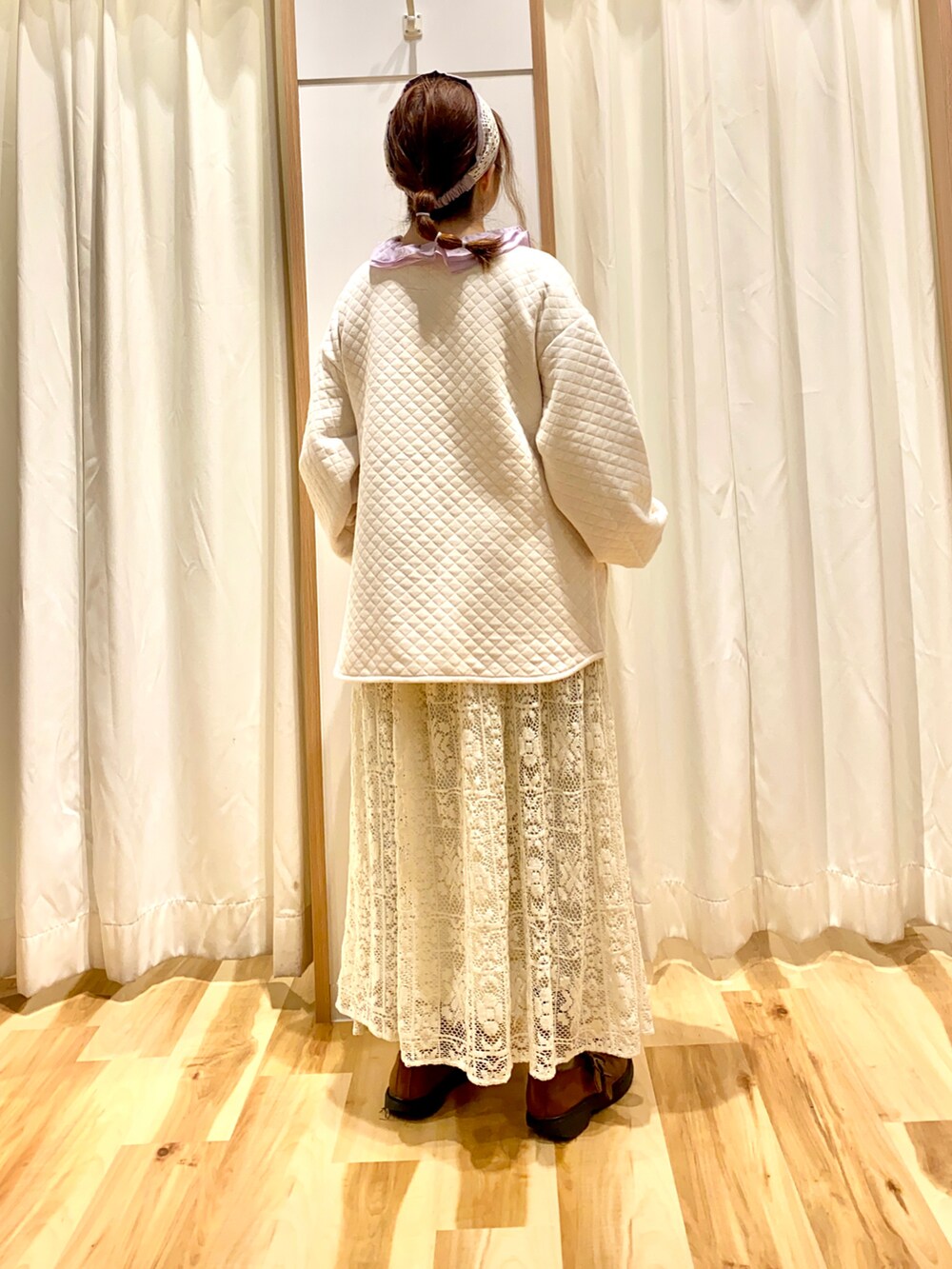 ホワイト系のノーカラージャケット、パープル系のシャツ/ブラウス、ホワイト系のスカートを着用したレディースの春コーディネートの2枚目の写真