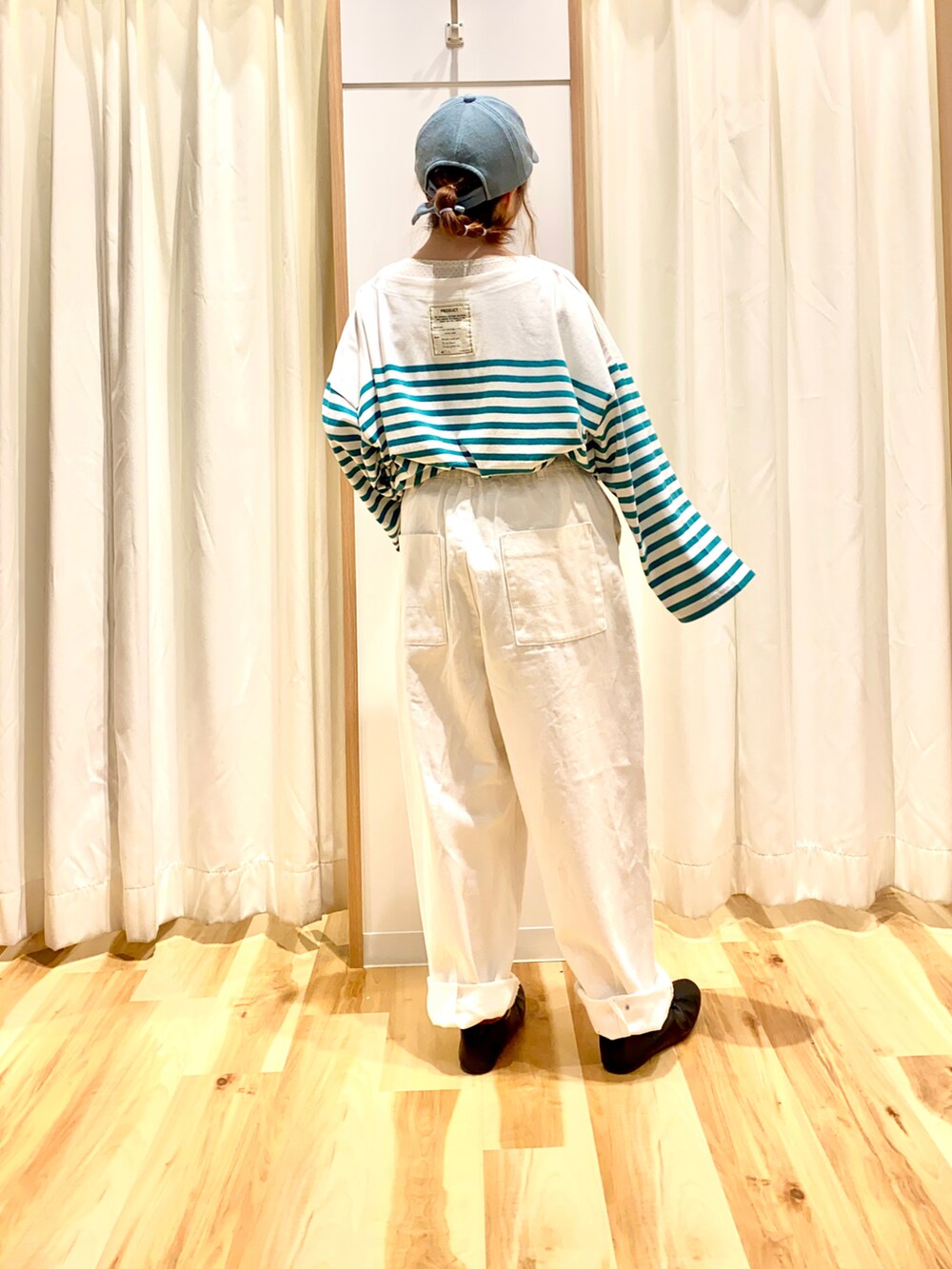 グリーン系のTシャツ/カットソー、ブルー系のカーディガン/ボレロ、ホワイト系のデニムパンツを着用したレディースの春コーディネートの2枚目の写真