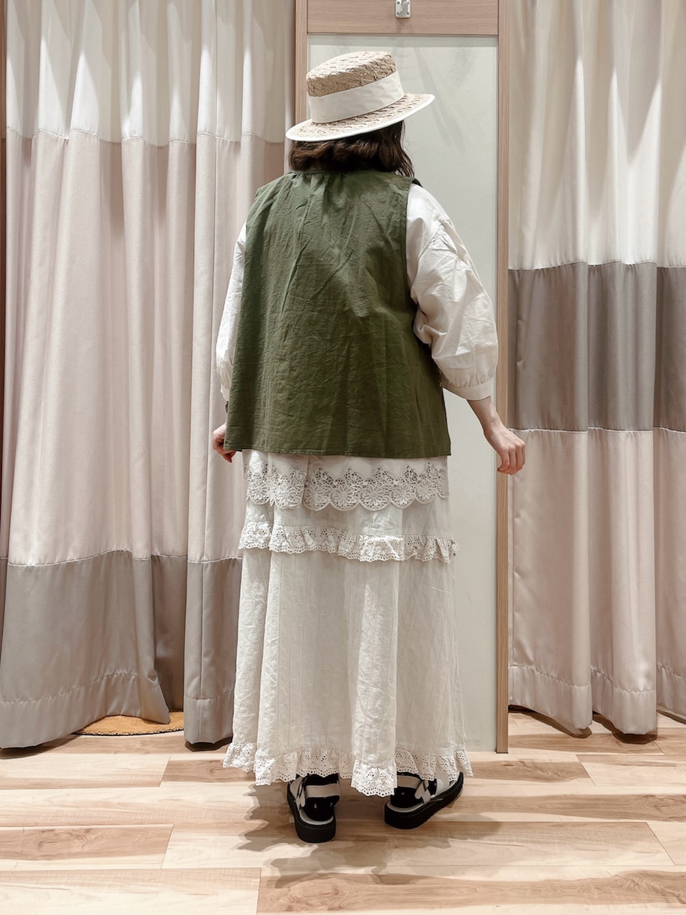 グリーン系のベスト、ホワイト系のシャツ/ブラウス、ベージュ系のスカートを着用したレディースの夏コーディネートの2枚目の写真