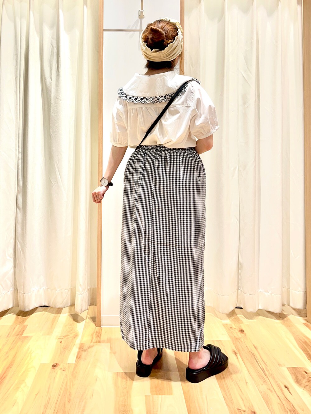 ホワイト系のシャツ/ブラウス、ブラック系のスカート、ブラック系のショルダーバッグを着用したレディースの夏コーディネートの2枚目の写真