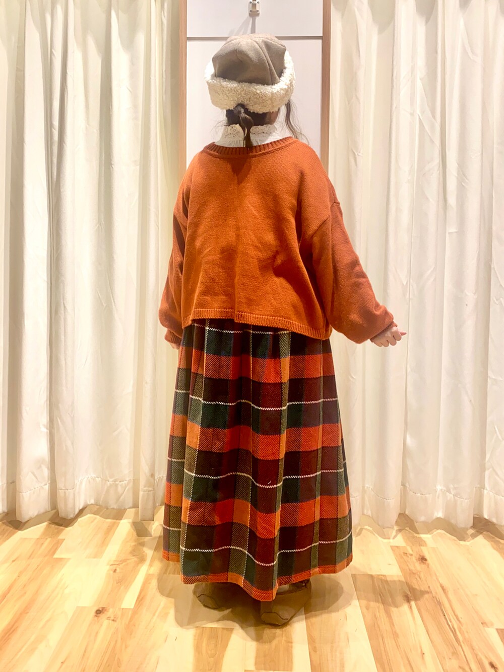 レッド系のカーディガン/ボレロ、ホワイト系のシャツ/ブラウス、オレンジ系のスカートを着用したレディースの冬コーディネートの3枚目の写真