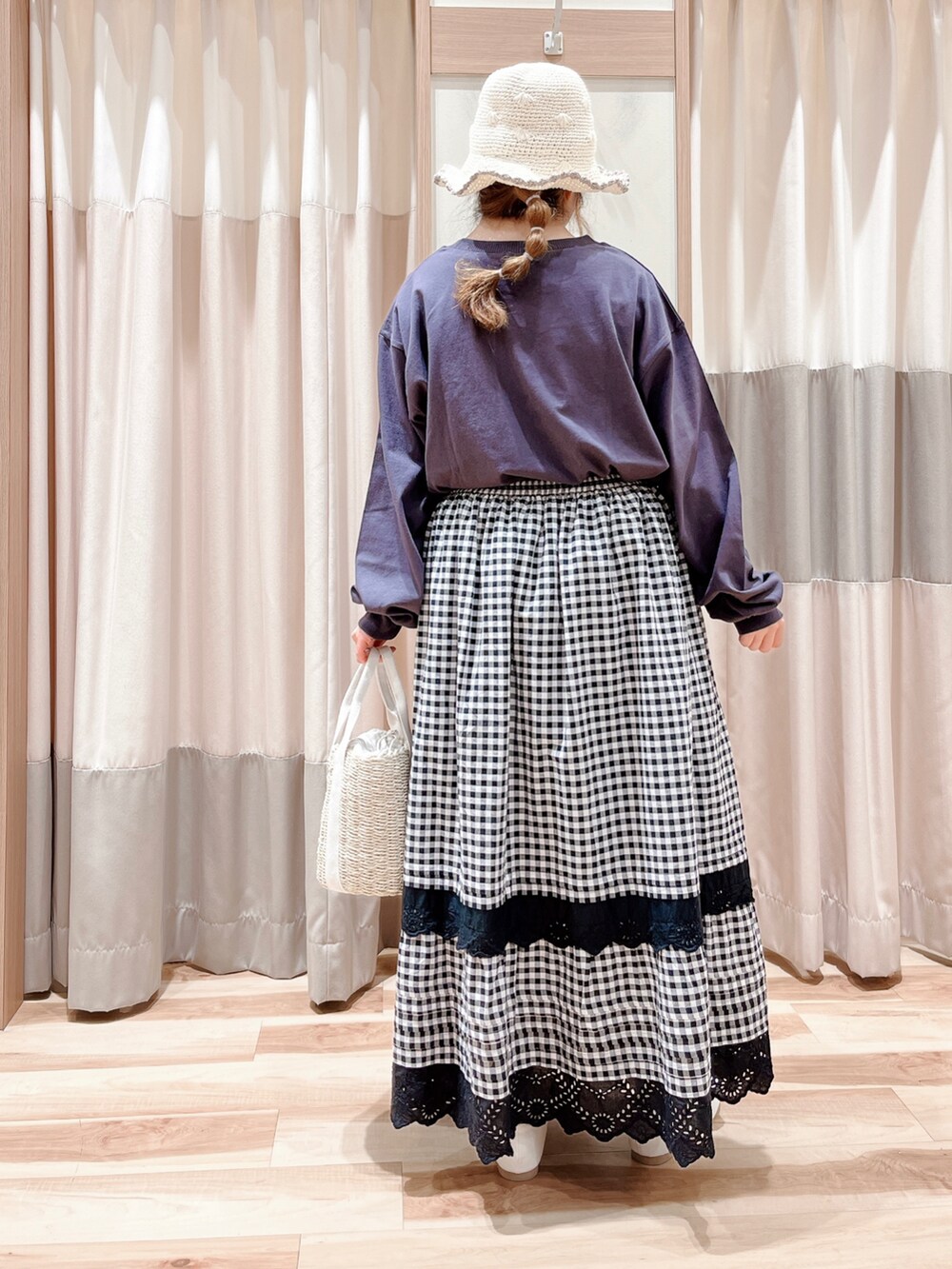 グレー系のTシャツ/カットソー、グレー系のスカート、ホワイト系のハンドバッグを着用したレディースの春コーディネートの2枚目の写真