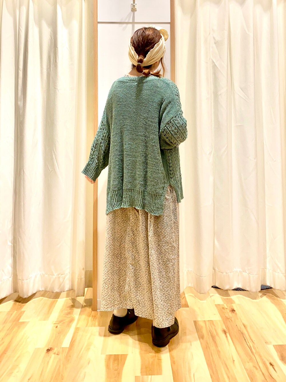 グリーン系のカーディガン/ボレロ、グリーン系のワンピース、ブラック系のドレスシューズを着用したレディースの春コーディネートの2枚目の写真