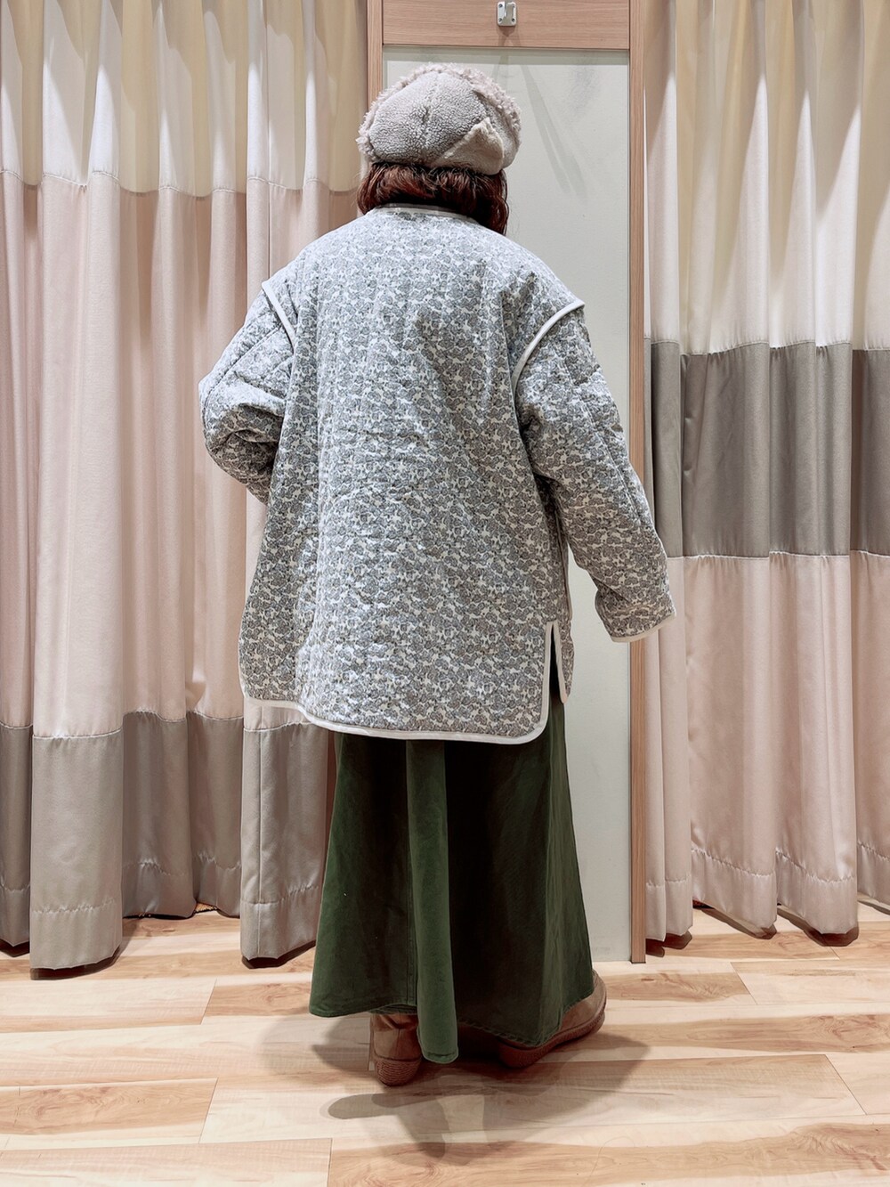 ホワイト系のノーカラージャケット、グレー系のシャツ/ブラウス、グリーン系のワンピースを着用したレディースの冬コーディネートの2枚目の写真