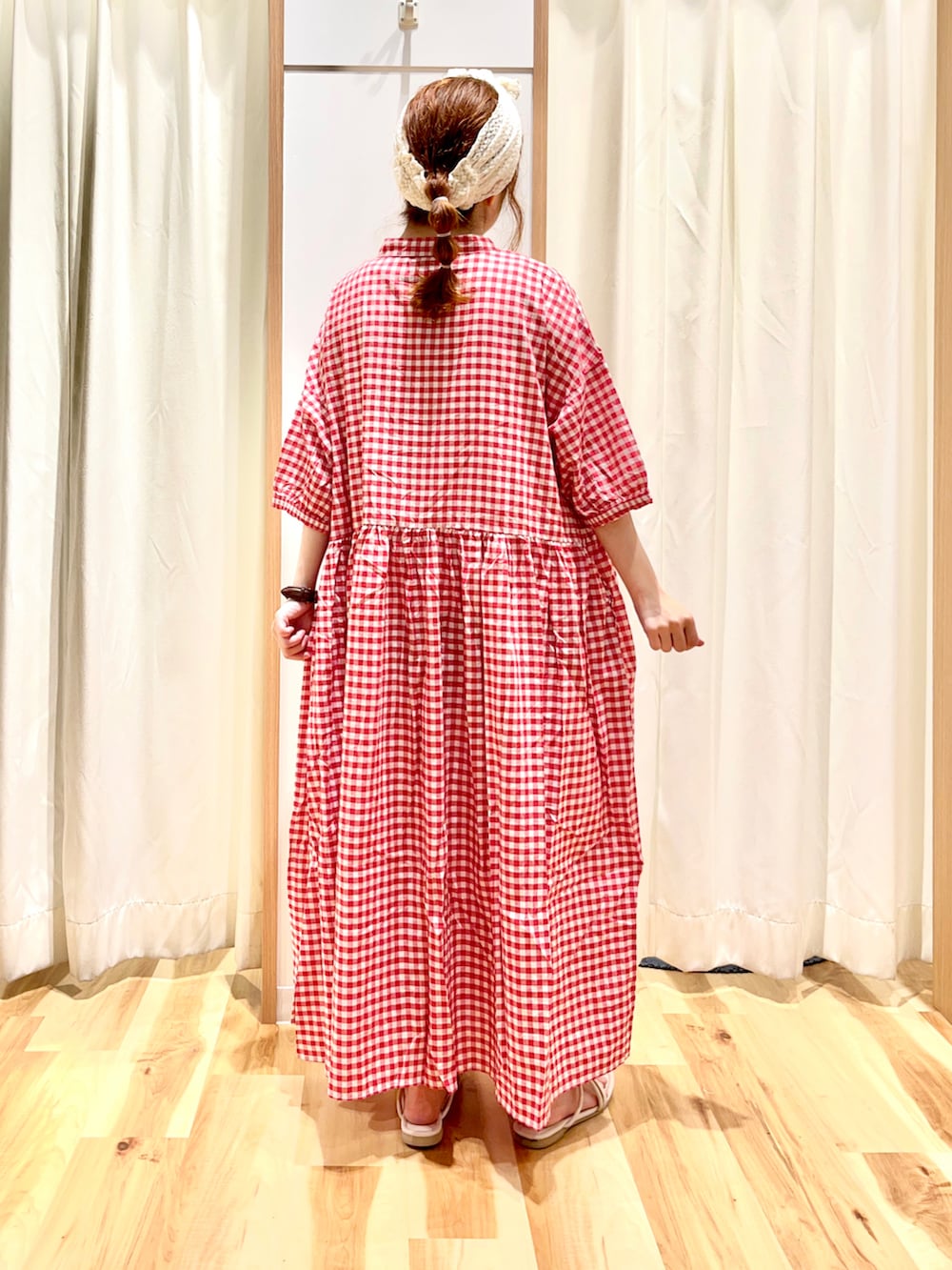 レッド系のワンピース、ホワイト系のサンダル、ホワイト系のヘアバンドを着用したレディースの夏コーディネートの2枚目の写真