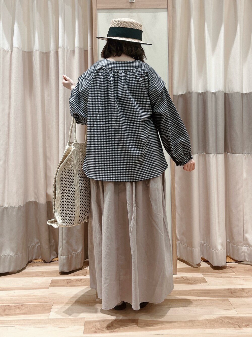 ブラック系のシャツ/ブラウス、ベージュ系のスカート、ホワイト系のハンドバッグを着用したレディースの夏コーディネートの2枚目の写真