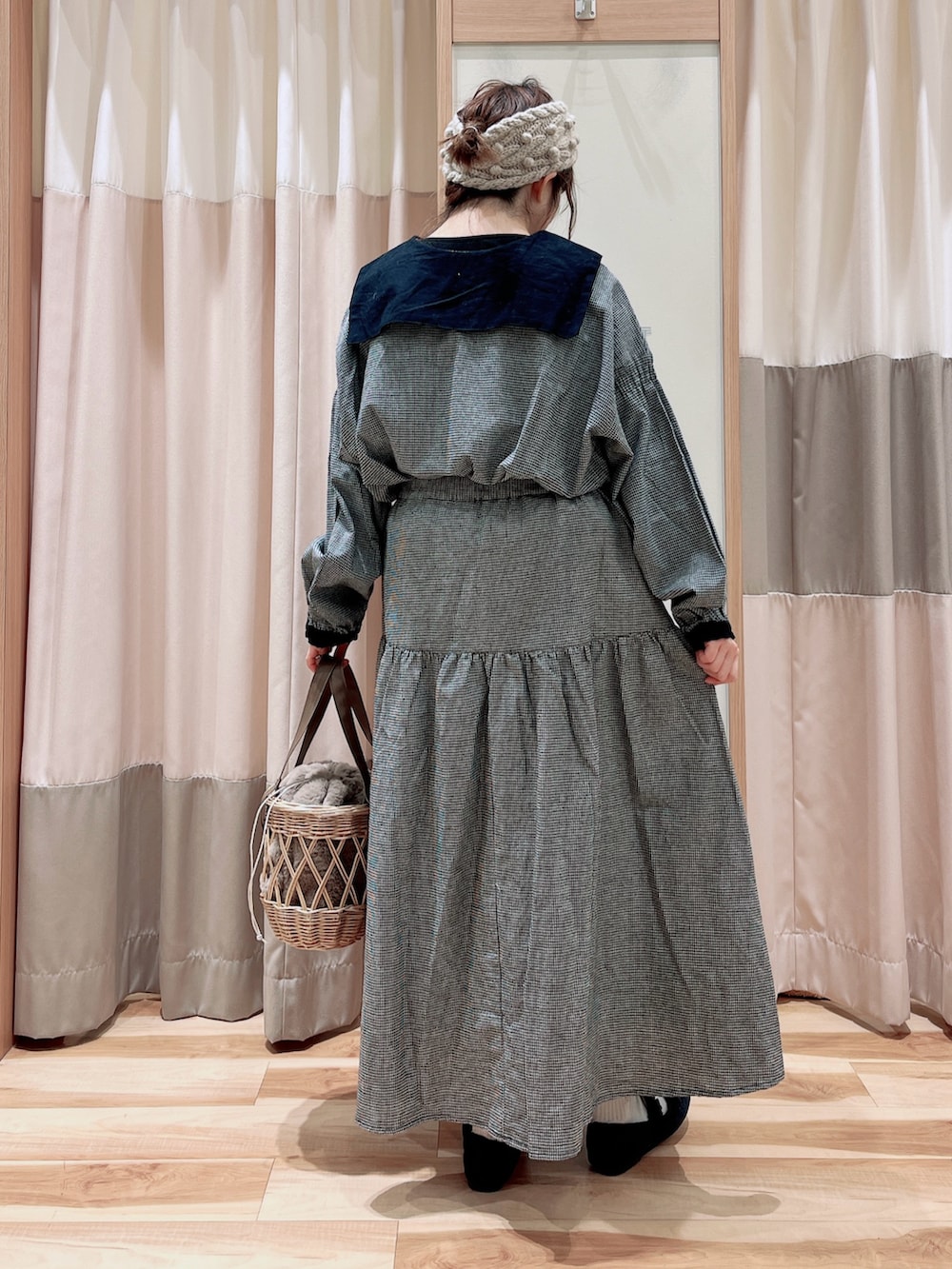 グレー系のシャツ/ブラウス、グレー系のスカート、ベージュ系のハンドバッグを着用したレディースの冬コーディネートの2枚目の写真