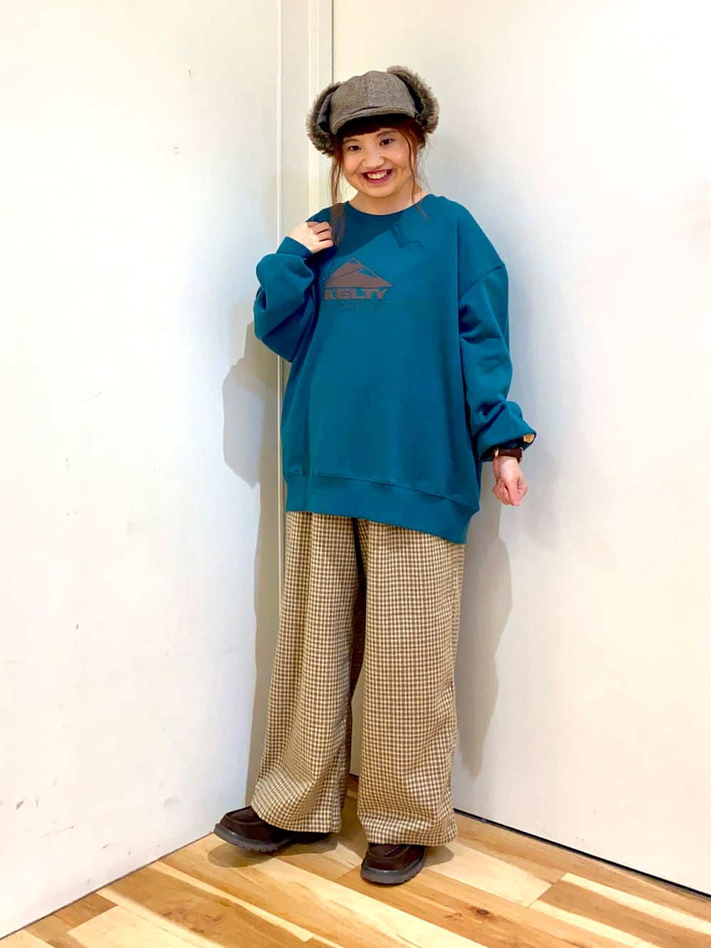 グリーン系のスウェット、ブラウン系のカーディガン/ボレロ、ブラウン系のその他パンツを着用したレディースの秋コーディネートの2枚目の写真