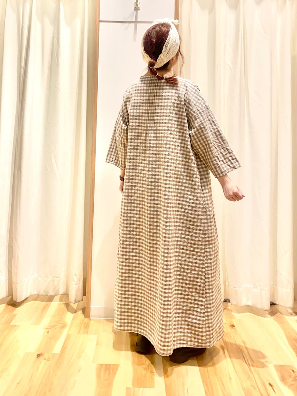 ベージュ系のワンピース、パープル系のTシャツ/カットソー、ブルー系のデニムパンツを着用したレディースの春コーディネートの2枚目の写真