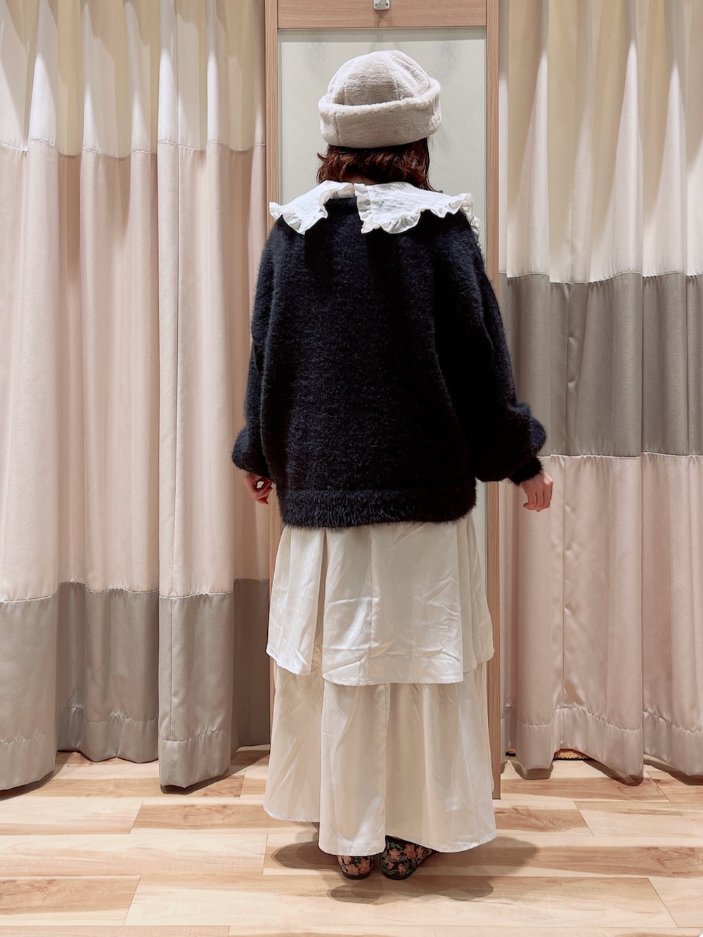 グレー系のカーディガン/ボレロ、ホワイト系のシャツ/ブラウス、ホワイト系のスカートを着用したレディースの秋コーディネートの2枚目の写真