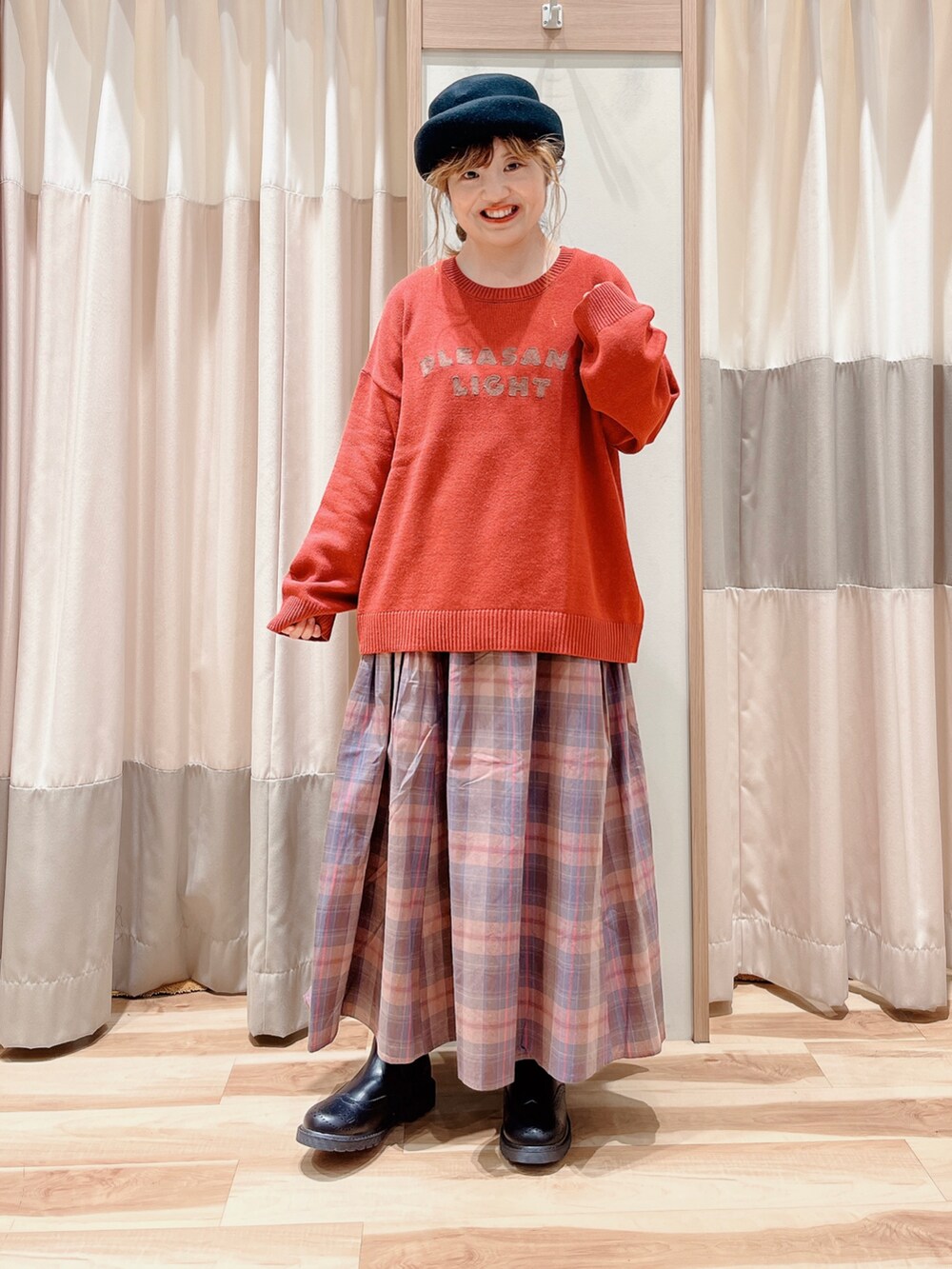 ベージュ系のベスト、レッド系のニット/セーター、ピンク系のスカートを着用したレディースの秋コーディネートの3枚目の写真