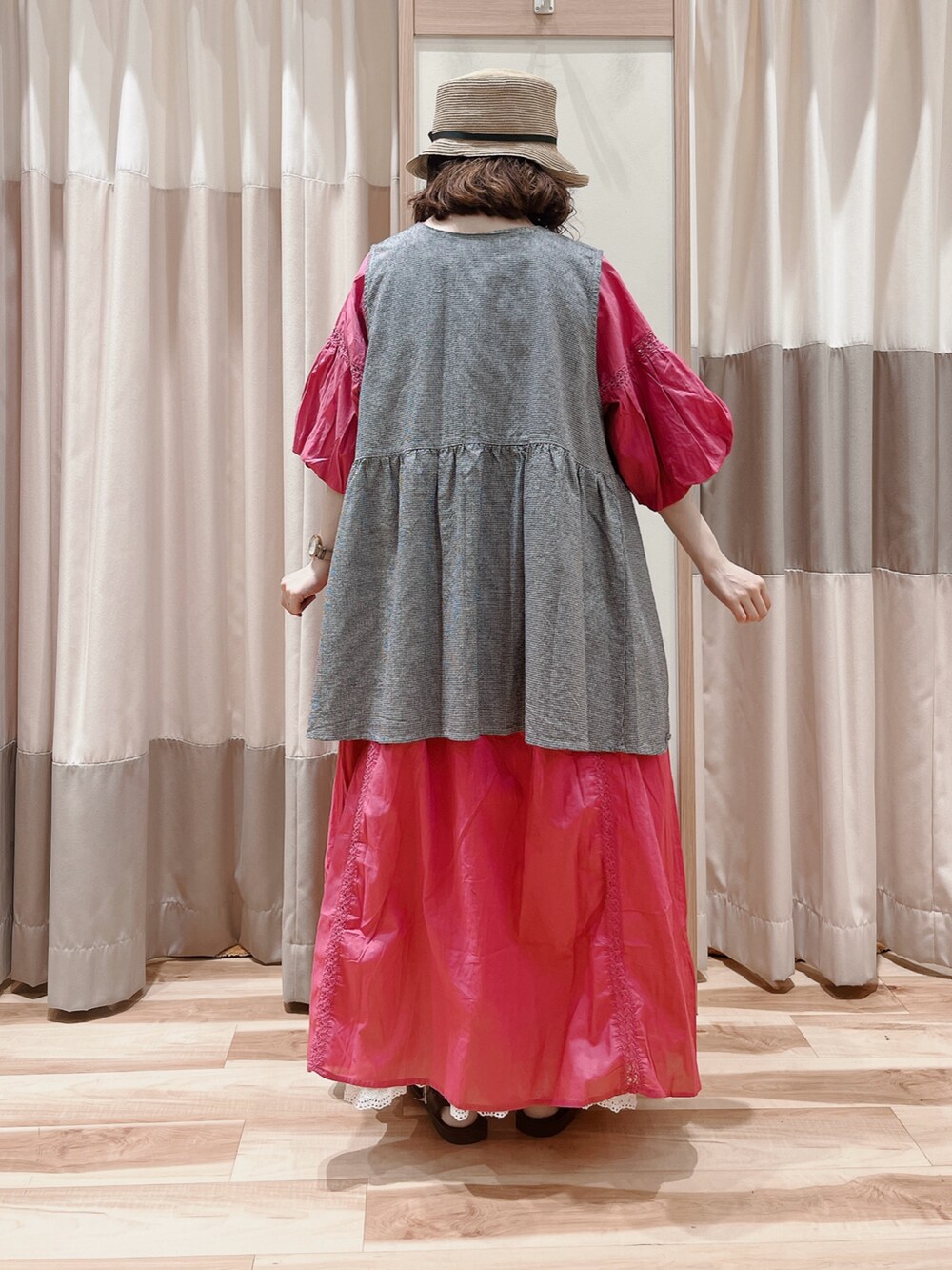 ピンク系のワンピース、グレー系のベスト、ホワイト系のスカートを着用したレディースの夏コーディネートの2枚目の写真