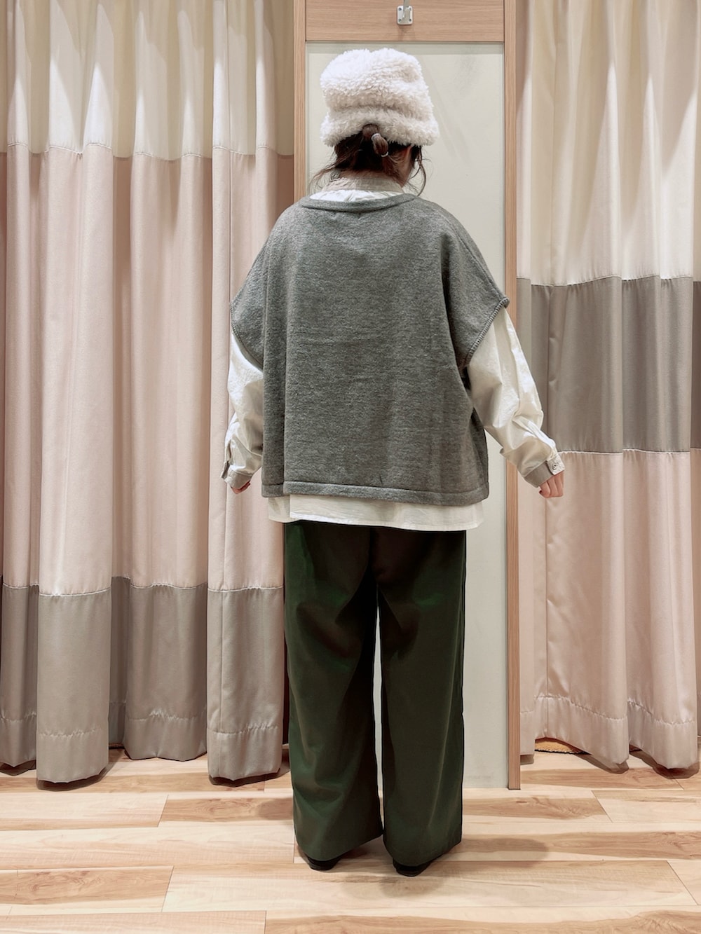 ホワイト系のシャツ/ブラウス、ベージュ系のベスト、グリーン系のスラックスを着用したレディースの冬コーディネートの2枚目の写真