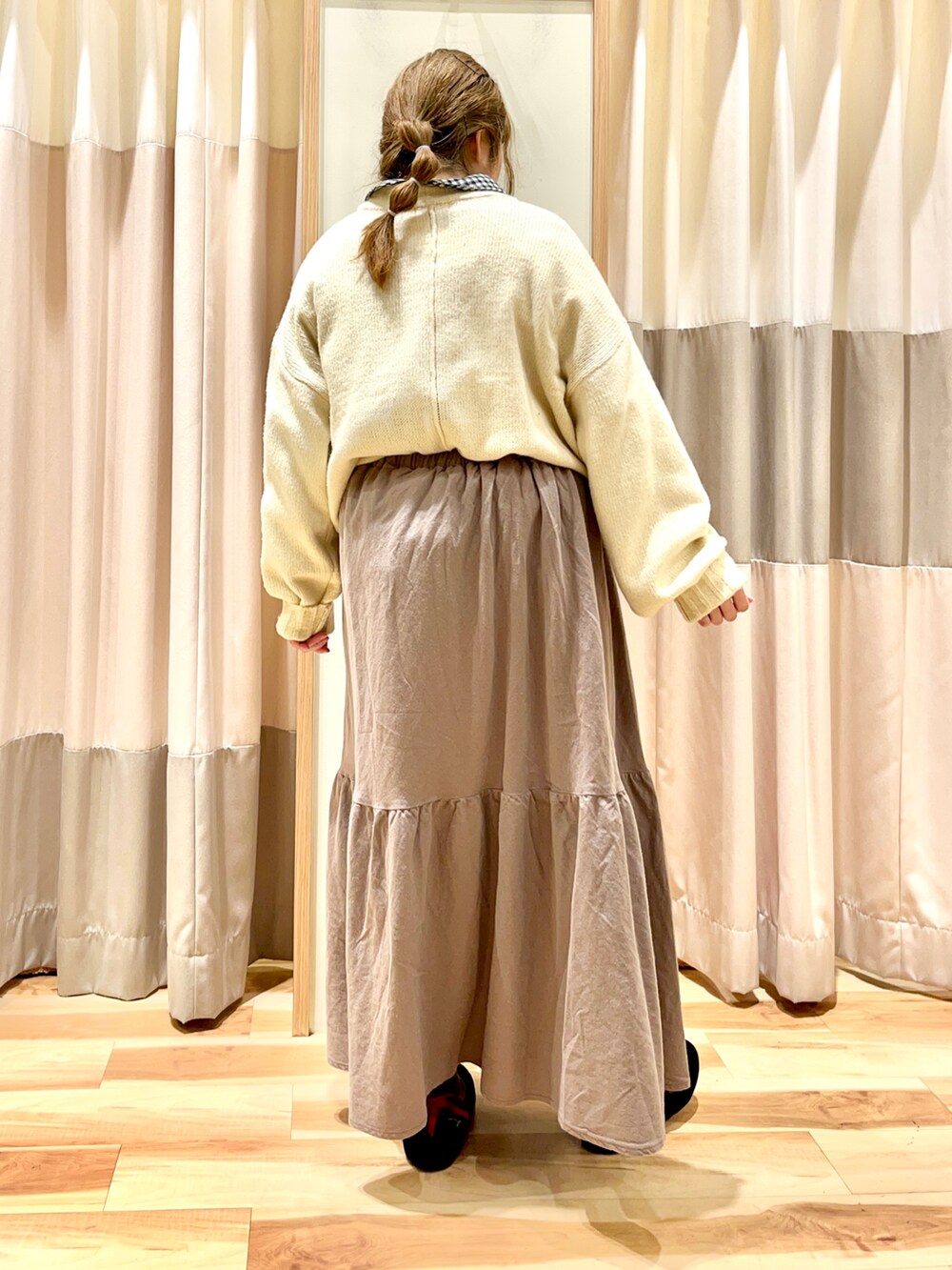 ホワイト系のニット/セーター、ブラック系のシャツ/ブラウス、ブラウン系のスカートを着用したレディースの冬コーディネートの2枚目の写真