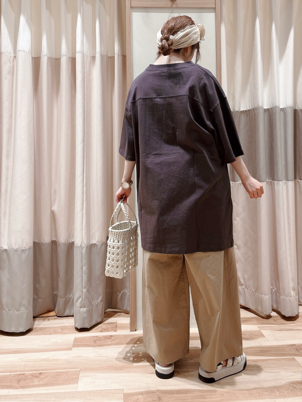 グレー系のTシャツ/カットソー、ベージュ系のその他パンツ、ホワイト系のハンドバッグを着用したレディースの夏コーディネートの2枚目の写真