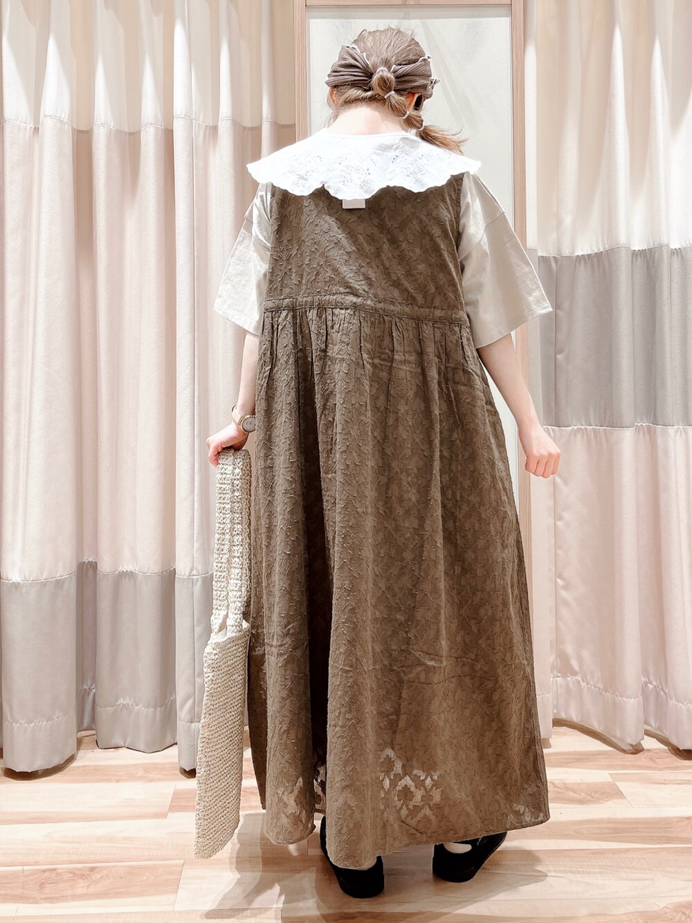 ベージュ系のTシャツ/カットソー、ブラウン系のワンピース、ホワイト系のハンドバッグを着用したレディースの春コーディネートの2枚目の写真
