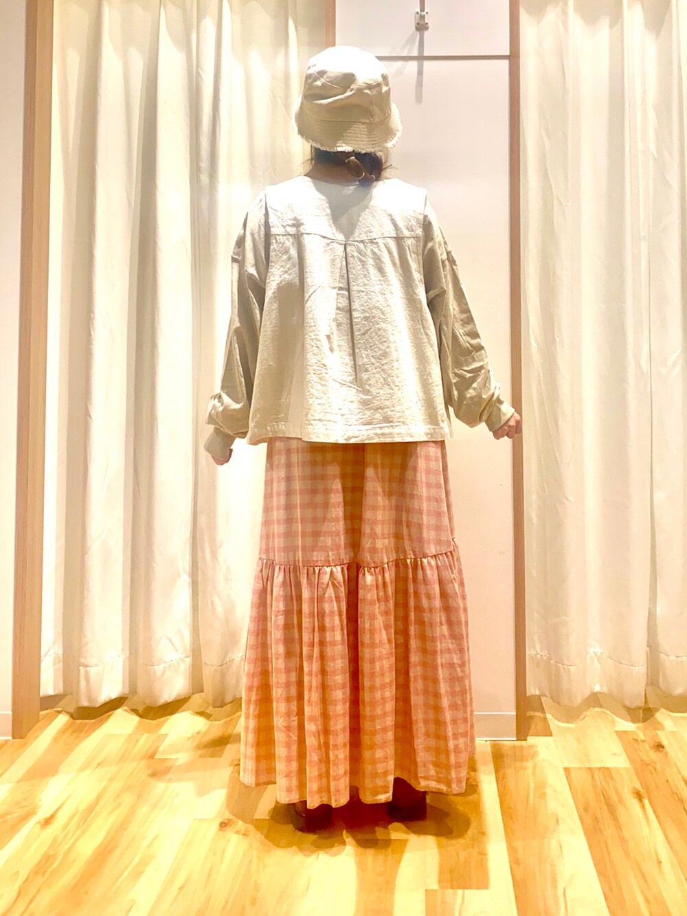 ホワイト系のベスト、ベージュ系のTシャツ/カットソー、ピンク系のスカートを着用したレディースの春コーディネートの2枚目の写真