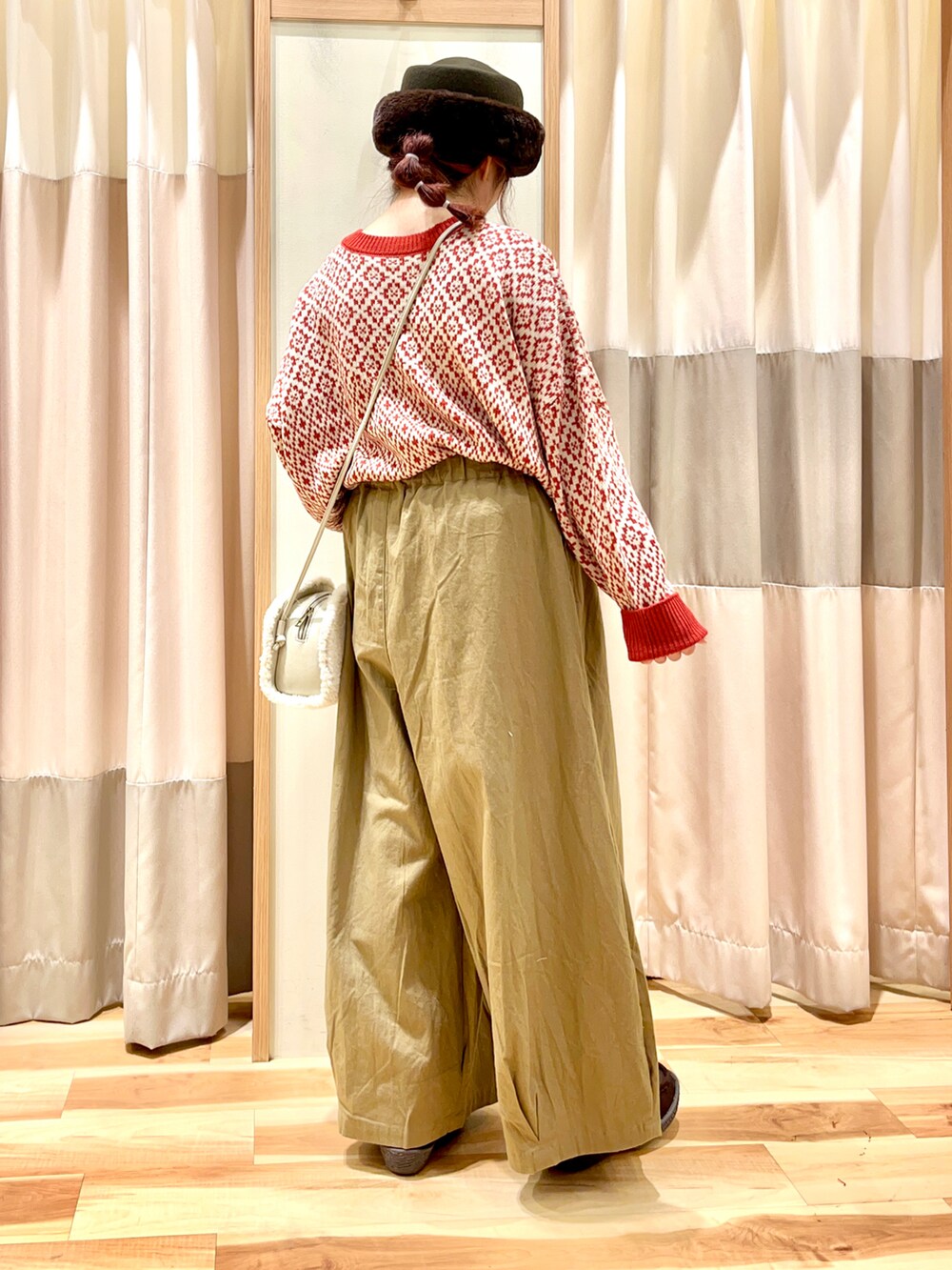 レッド系のカーディガン/ボレロ、ホワイト系のハンドバッグ、ブラウン系のブーツを着用したレディースの秋コーディネートの2枚目の写真