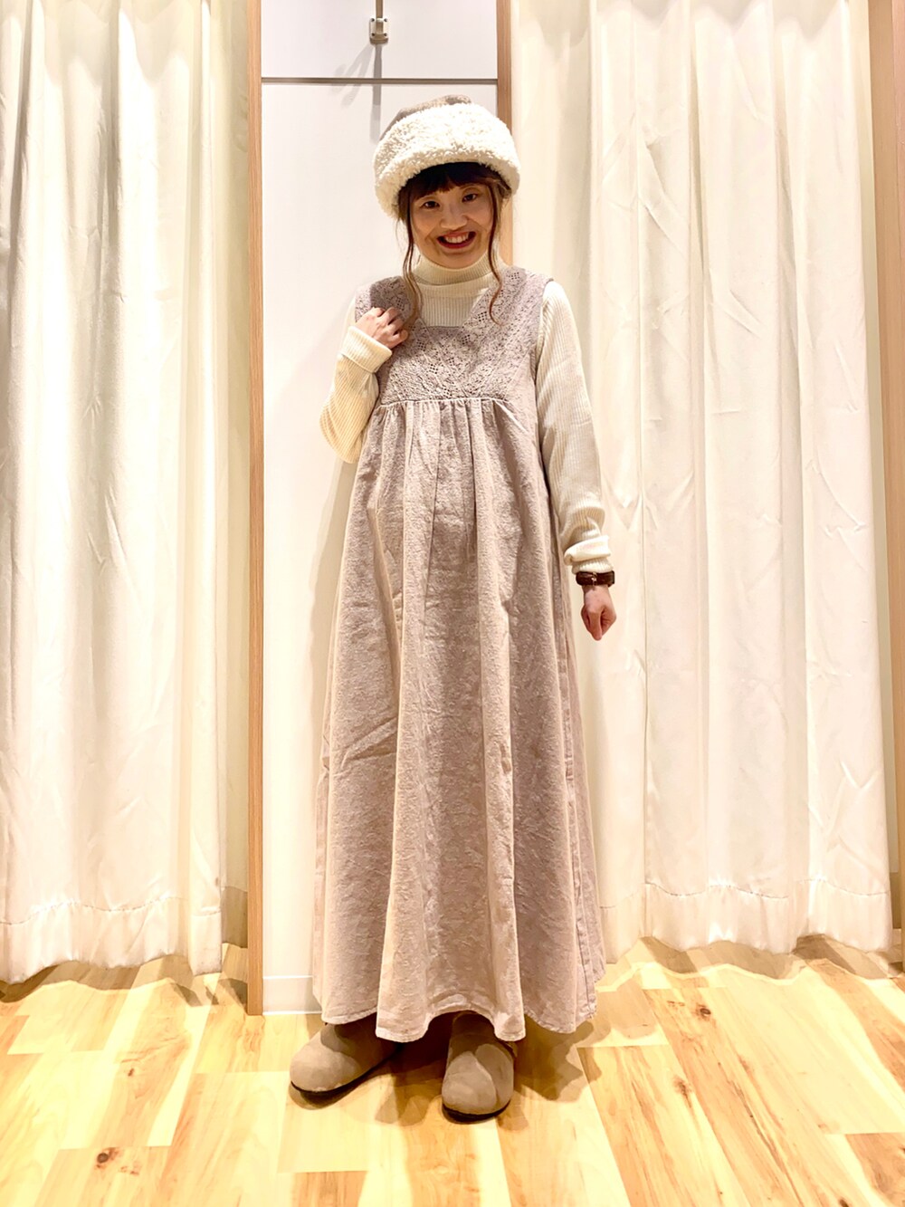 ブラウン系のワンピース、ホワイト系のニット/セーター、グレー系のベストを着用したレディースの冬コーディネートの3枚目の写真