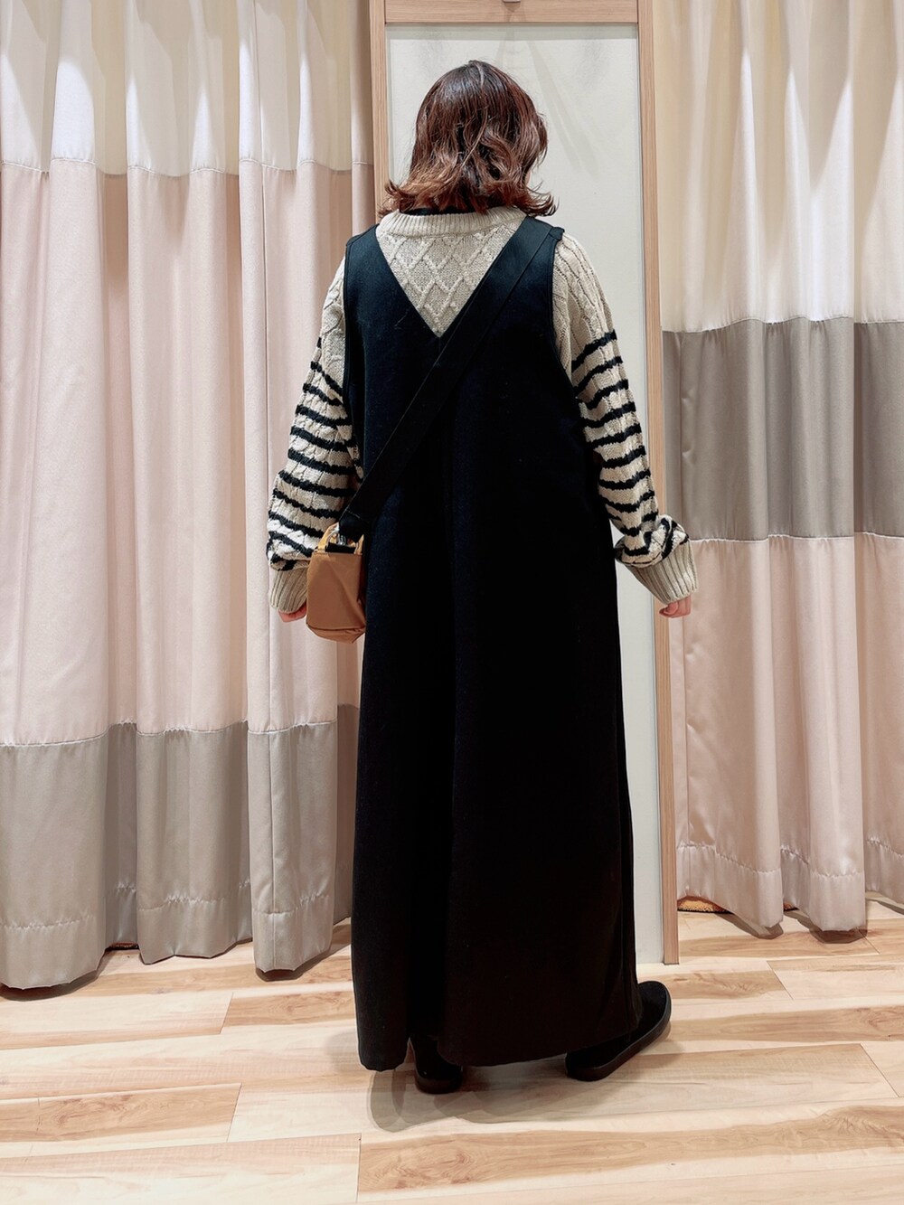 ブラック系のサロペット/オーバーオール、ベージュ系のニット/セーター、イエロー系のハンドバッグを着用したレディースの冬コーディネートの2枚目の写真