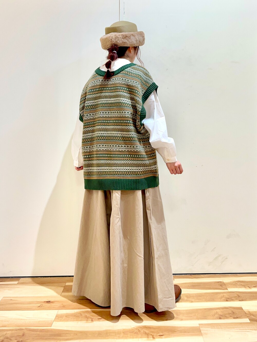 グリーン系のベスト、ホワイト系のシャツ/ブラウス、ベージュ系のその他パンツを着用したレディースの秋コーディネートの2枚目の写真