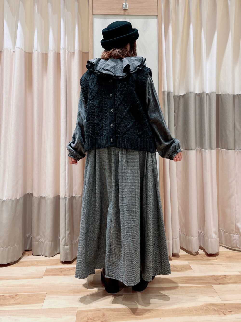 グレー系のベスト、グレー系のシャツ/ブラウス、ブラック系のスカートを着用したレディースの冬コーディネートの2枚目の写真