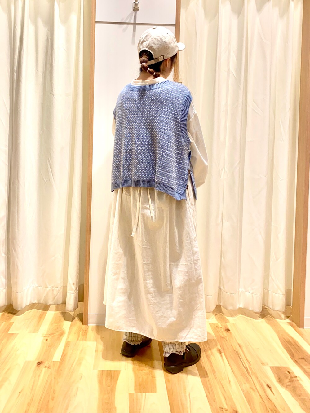 ブルー系のベスト、ホワイト系のワンピース、グレー系のその他パンツを着用したレディースの春コーディネートの2枚目の写真