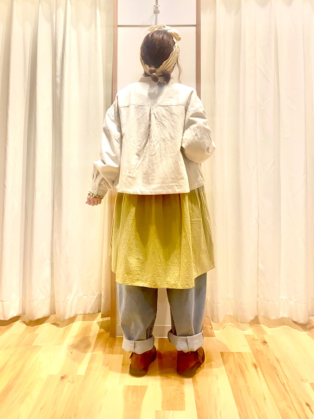 ホワイト系のブルゾン、イエロー系のシャツ/ブラウス、ブルー系のデニムパンツを着用したレディースの春コーディネートの2枚目の写真