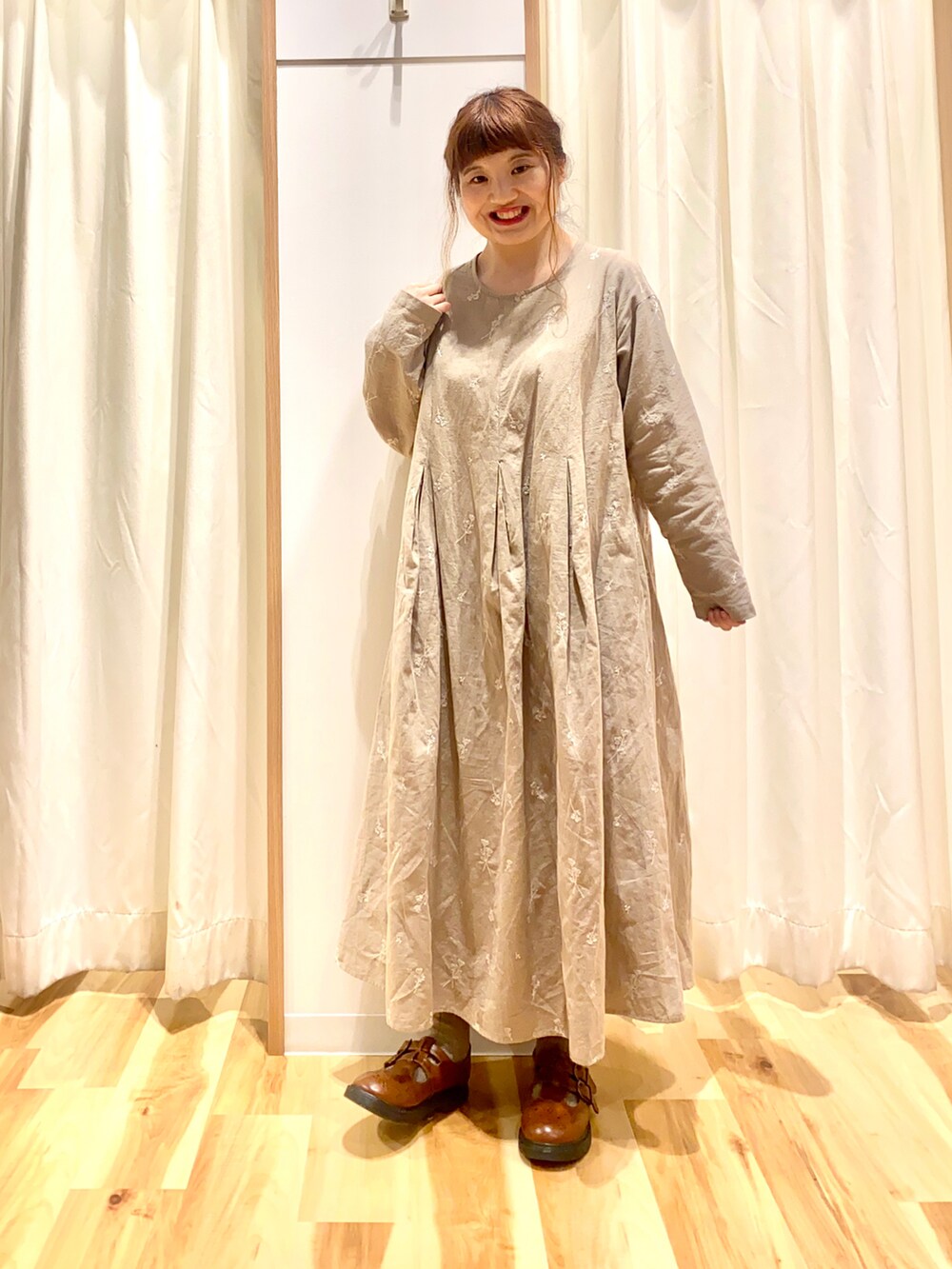 ホワイト系のベスト、ベージュ系のワンピース、イエロー系のドレスシューズを着用したレディースの春コーディネートの3枚目の写真