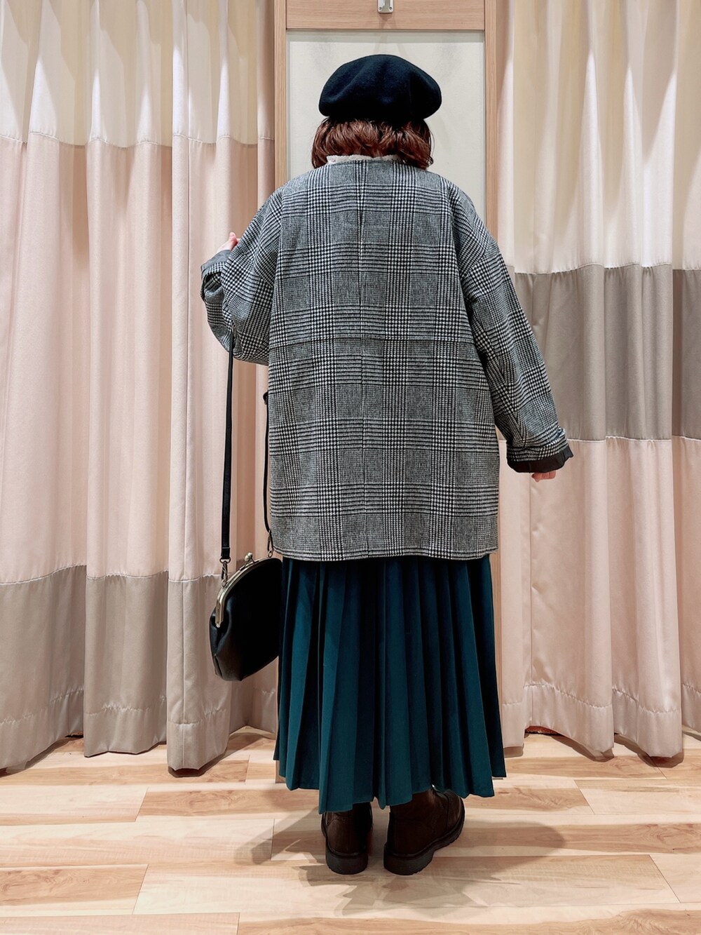 ホワイト系のシャツ/ブラウス、ブラック系のその他アウター、グリーン系のスカートを着用したレディースの冬コーディネートの2枚目の写真