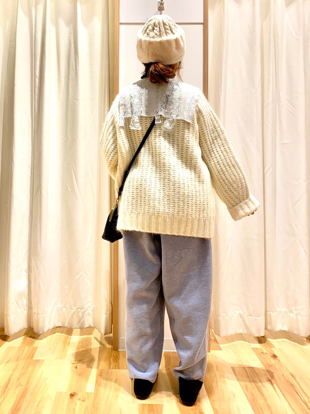 ホワイト系のニット/セーター、ブルー系のワンピース、ブラック系のニット/セーターを着用したレディースの冬コーディネートの2枚目の写真